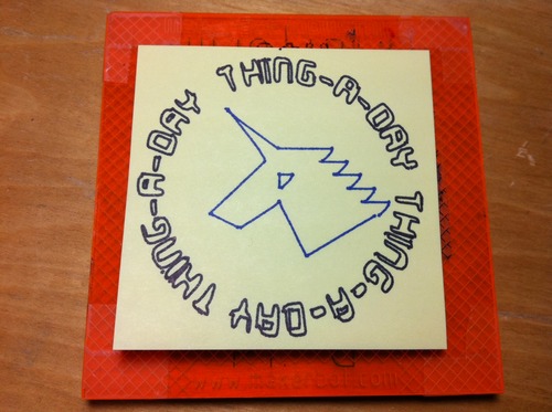 Post-it note with drawing of a geometric unicorn in blue and surrounding 'thing-a-day' text in a circular pattern in black.