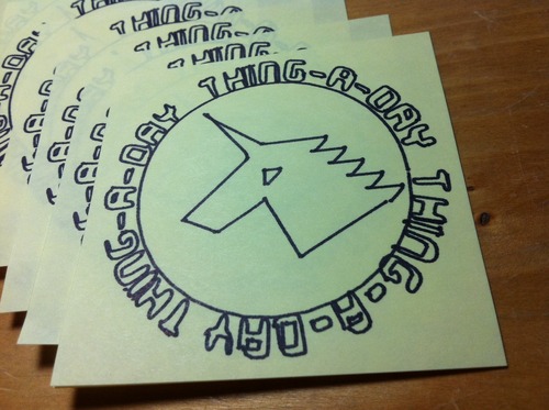 A stack of sticky notes featuring plotted art of a geometric unicorn inside a circle surrounded by the words 'thing-a-day' repeated 3 times.
