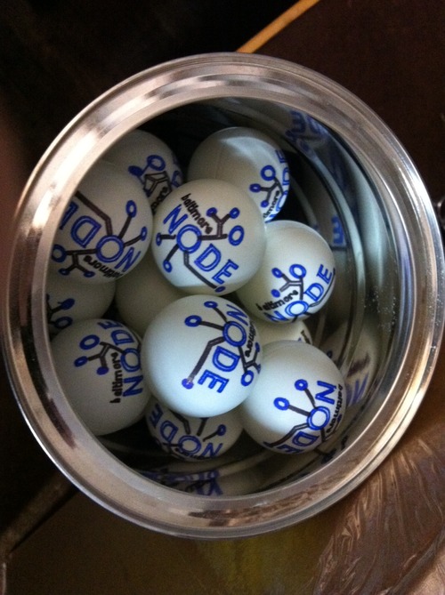 A coffee can full of ping-pong balls, each inscribed with a two-color Baltimore Node logo.